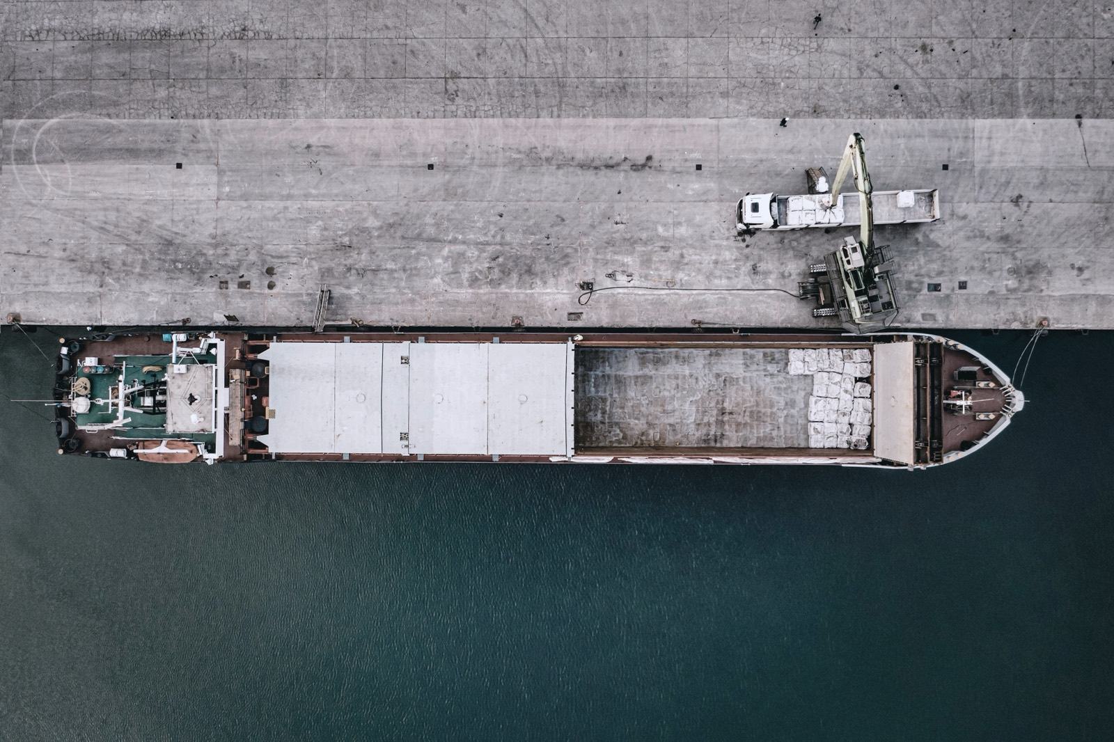 Aerial top-down view of a cargo vessel loading at a berth